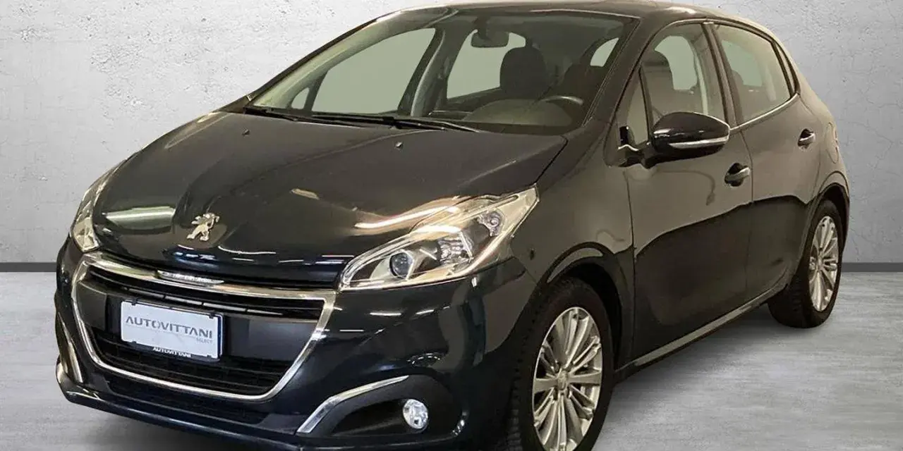 Peugeot 208 grigia, ideale per la città. Controlla la pressione gomme per un viaggio sicuro.