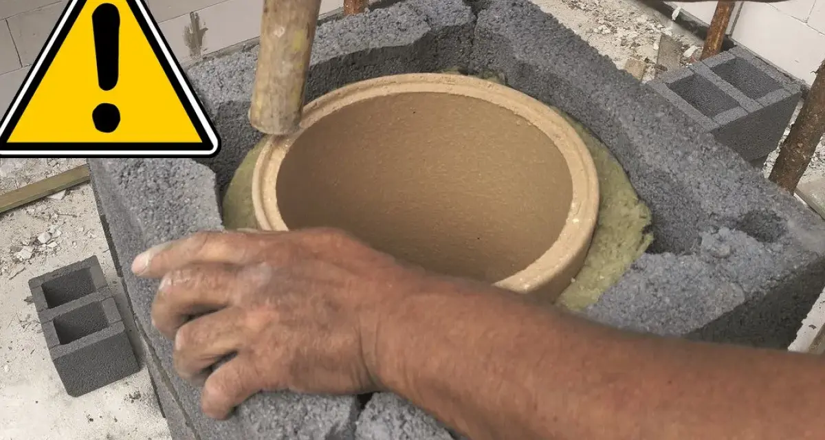 Ręce montują ceramiczny czopuch w konstrukcji z pustaków. Ostrzeżenie przed pracami budowlanymi.