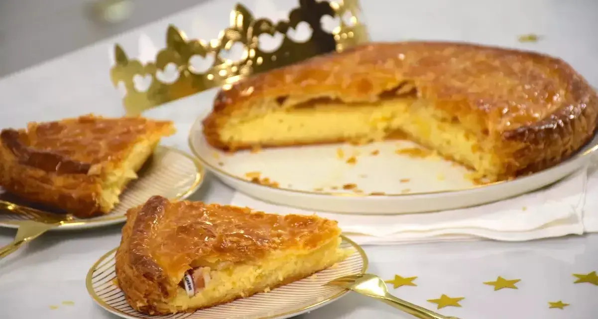 Une galette de farine dorée, prête à être dégustée, avec une fève cachée dans une part. Une couronne dorée trône à côté, promesse de fête.