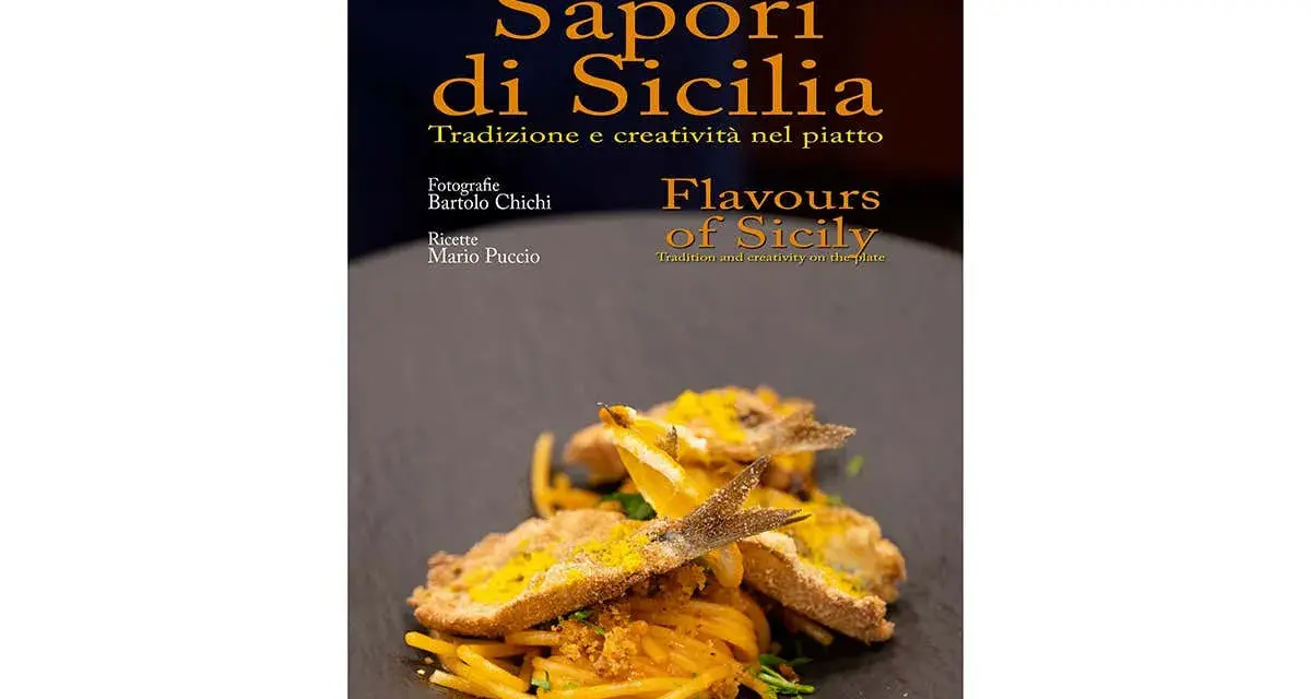 Un piatto di spaghetti con pesce fritto e scorza d'arancia, che celebra i sapori tipici siciliani.