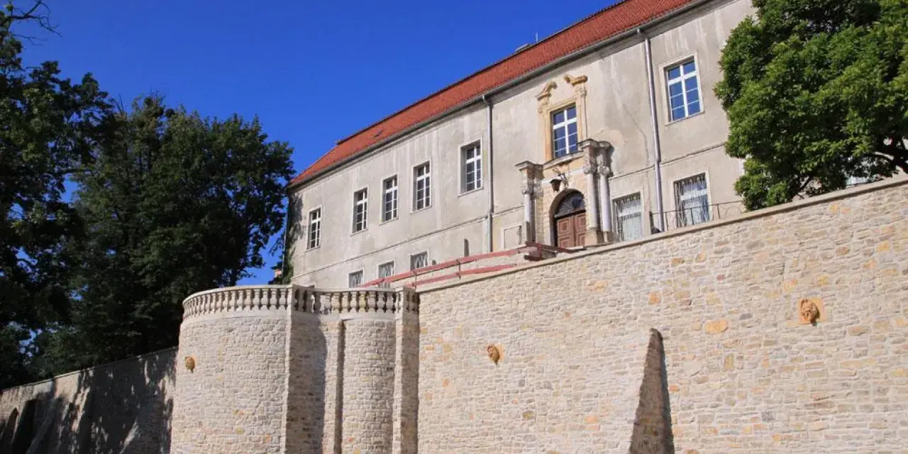 Krapkowice zamek zwiedzanie: kamienne mury i zabytkowy budynek zamku pod błękitnym niebem.