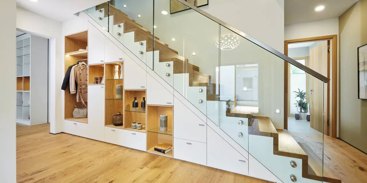 Schickes **schmales Reihenhaus einrichten**: Stauraumwunder unter der Treppe mit Garderobe, Regalen und Schubladen. Moderne Glasbrüstung.