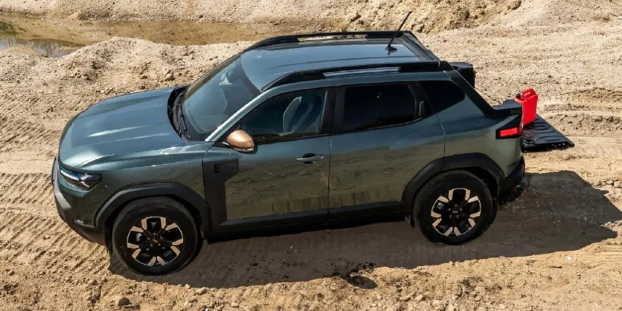 Zielony Dacia pickup z otwartą klapą bagażnika i czerwoną kanistrem na piasku.