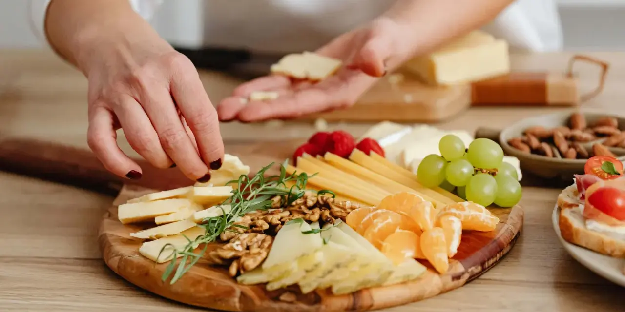 Tabla de quesos variados, frutos secos, uvas y gajos de mandarina, perfecta para unos entrantes saludables.