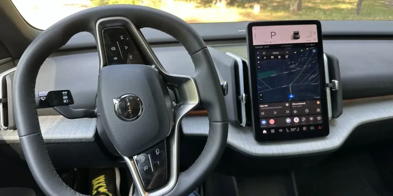Wnętrze Volvo V30 z ekranem nawigacji i kierownicą.