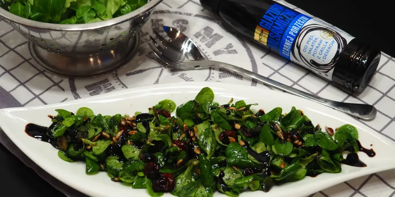 Pyszna sałatka z roszponką, polana sosem balsamicznym z czarnej porzeczki, posypana pestkami słonecznika i żurawiną.