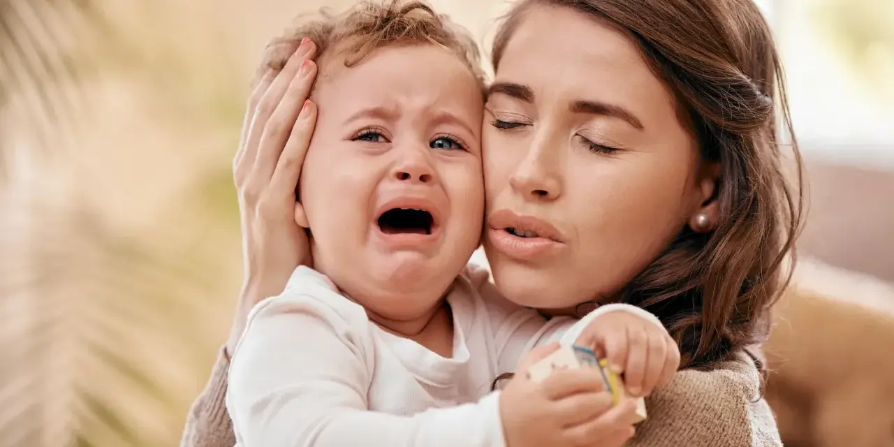Zmartwiona mama tuli płaczące dziecko. Czy to mamoza?