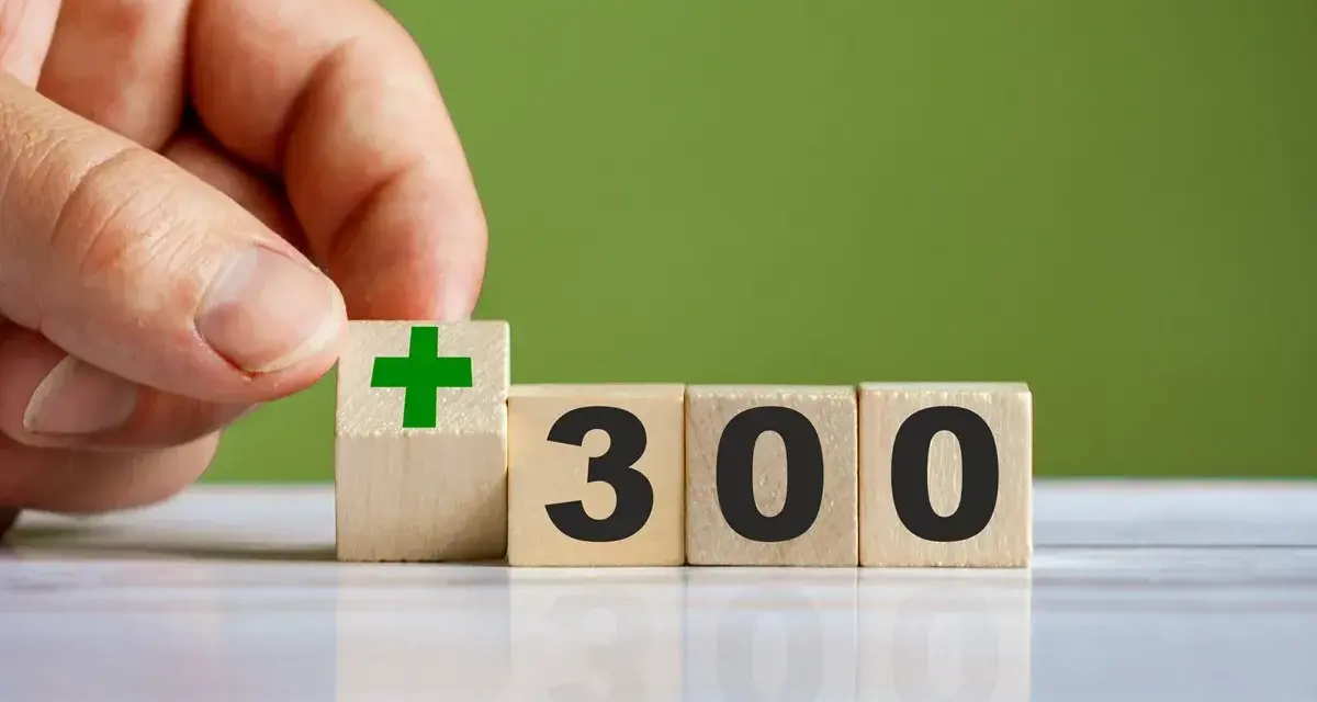 Dłoń układa kostkę z zielonym plusem obok kostek z napisem "300". To dobry start dla kogoś, kto chce zacząć coś nowego.
