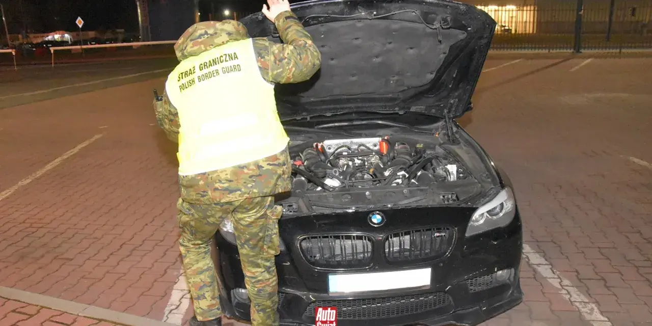 Funkcjonariusz Straży Granicznej sprawdza silnik BMW, wykonując rozkodowanie VIN.