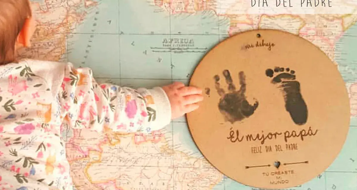 Manualidad Día del Padre 2 años: huella de mano y pie de bebé en un círculo de cartón sobre un mapa.