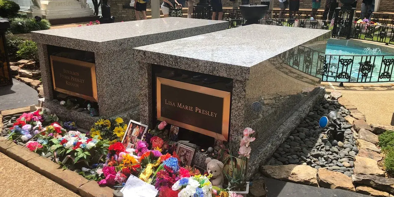 Gräber von Lisa Marie und Benjamin Keough, umgeben von Blumen. Viele Besucher ehren das Erbe von Elvis Presley.