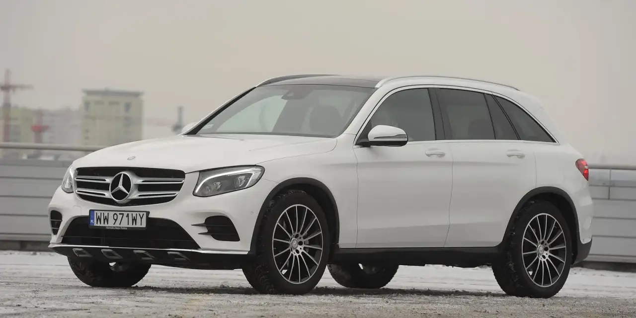 Biały Mercedes GLC 220d na tle miejskiego krajobrazu, gotowy na zimowe wyzwania.