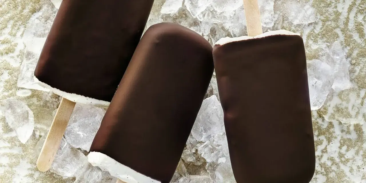 Drei Schokoladen-Vanilleeis am Stiel liegen auf Eiswürfeln.