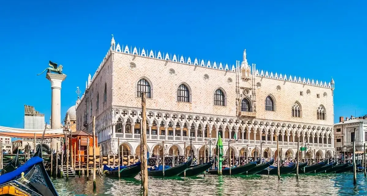 Gondole ormeggiate davanti a Palazzo Ducale, un must per chi cerca cosa vedere a Venezia. Il Leone di San Marco veglia sulla laguna.
