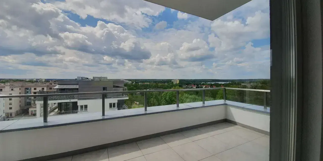 Przestronna loggia z widokiem na miasto i zieleń. Idealne miejsce na poranną kawę.