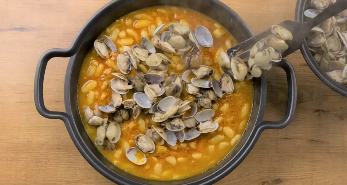 Plato humeante de fabes con almejas, un manjar tradicional.