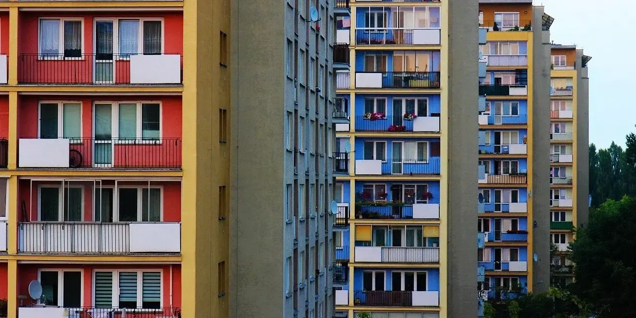 Rząd kolorowych bloków mieszkalnych z balkonami.