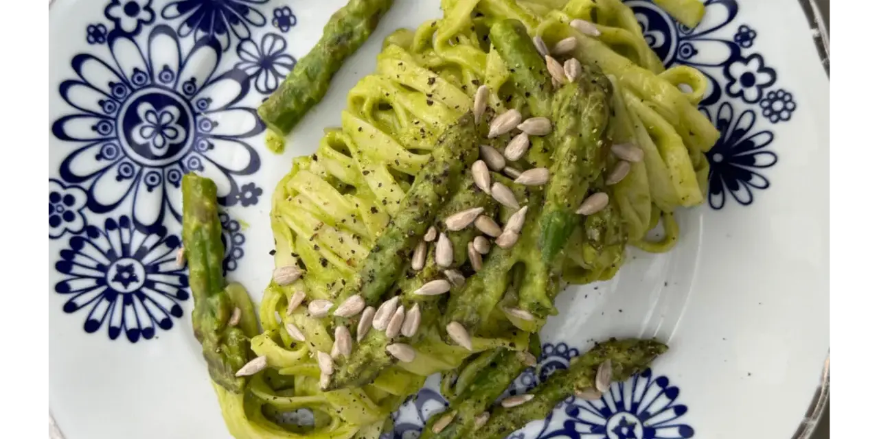 Makaron z zielonym pesto i szparagami, posypany pestkami słonecznika. Czy makaron jest zdrowy? Zależy od dodatków!