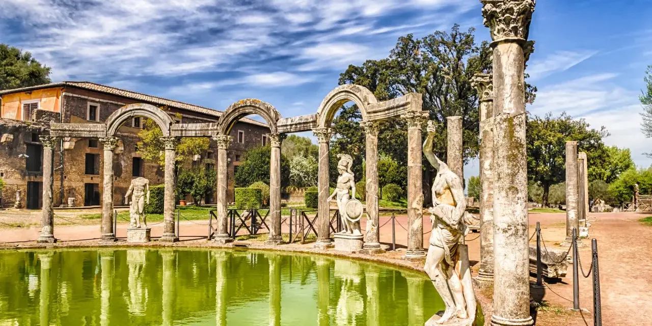 Starożytne ruiny i rzeźby w Villa d'Este odbijają się w zielonym stawie.