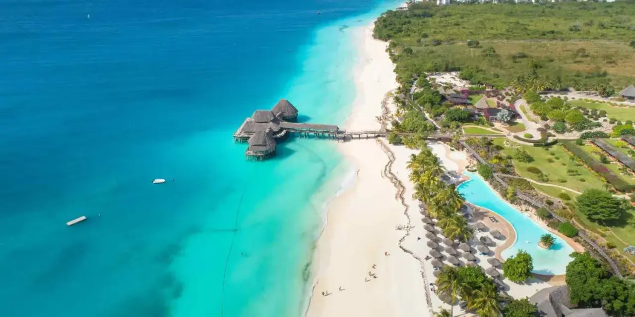 Rajskie plaże Zanzibar w lipcu: turkusowa woda, biały piasek, palmy i luksusowe bungalowy na wodzie. Idealne miejsce na wakacje.
