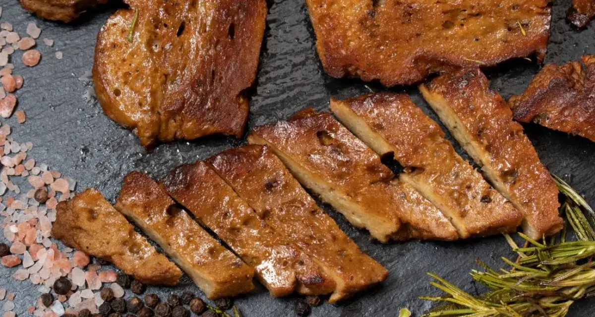 Pokrojony seitan, przypominający mięso, z rozmarynem i solą. To świetna alternatywa dla mięsa, jeśli zastanawiasz się, seitan co to.