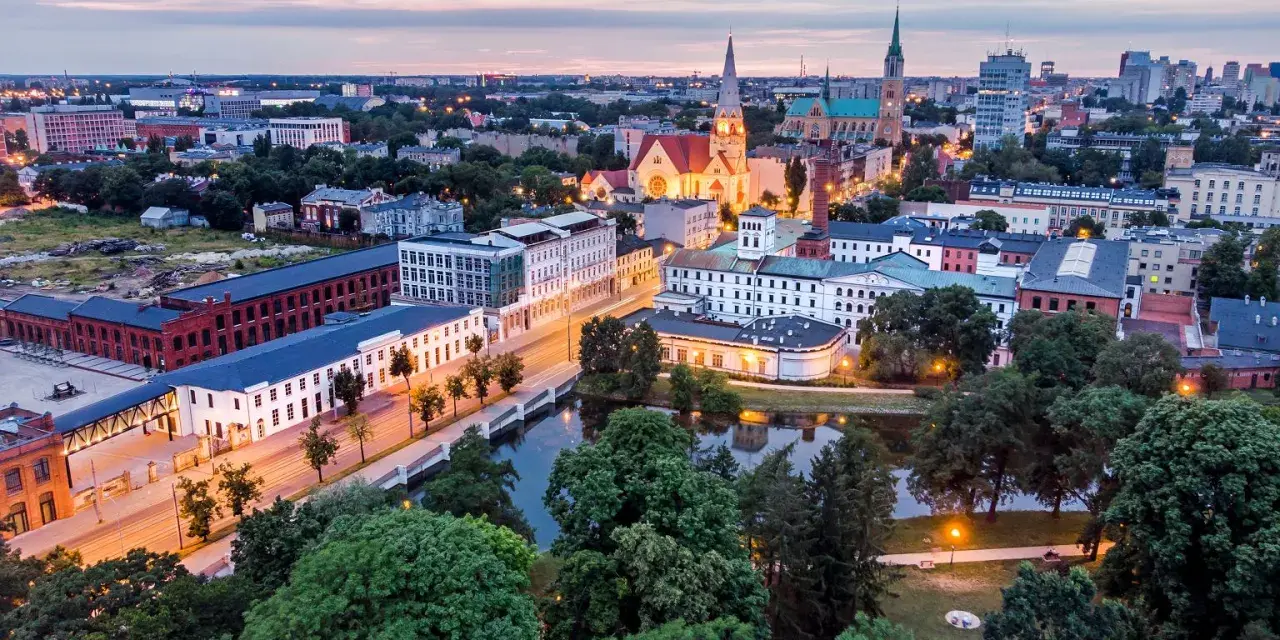 Widok na łódzką architekturę, w tym zabytkowe fabryki i kościoły. Idealne miejsce, by zobaczyć, co zwiedzić w Łodzi.