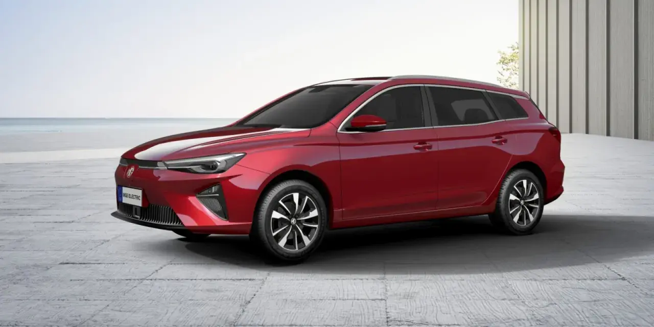 Czerwony MG5 Electric, kombi, stoi na betonowym placu z widokiem na morze.