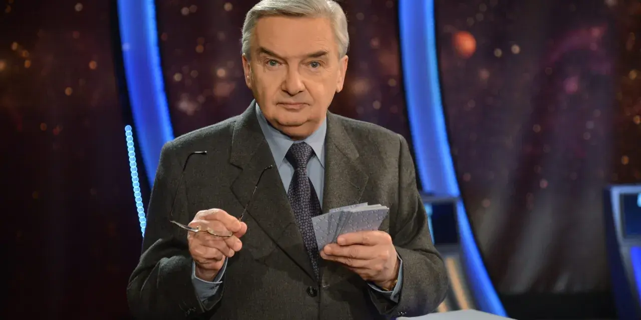 Starszy mężczyzna w garniturze trzyma okulary i karty z napisem "jeden z dziesięciu kiedy".