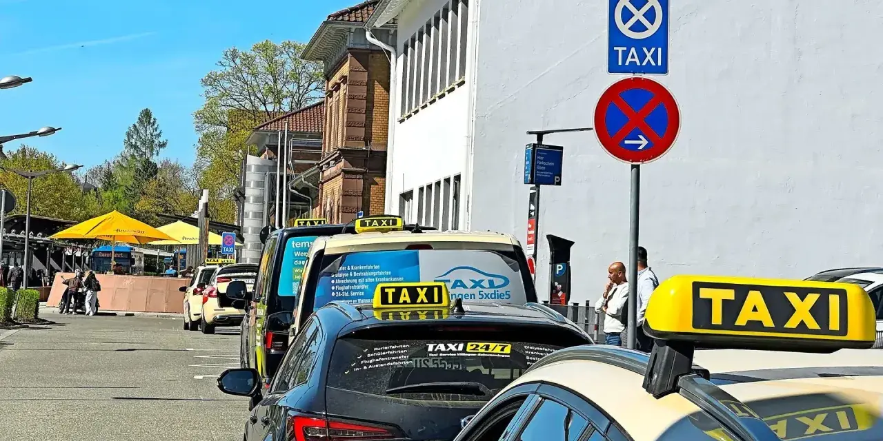 Taxistand mit Schildern. Was kostet eine Taxifahrt von 30 km? Die Schilder geben keine Auskunft über Preise.