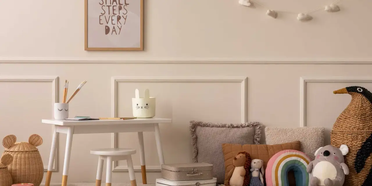 Ein Kinderzimmer mit einem kleinen Schreibtisch, Spielzeug und einem Bild mit der Aufschrift "Small steps every day". Eine beige Mom würde sich hier wohlfühlen.