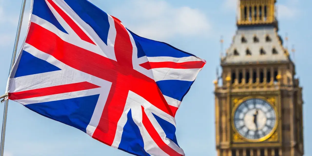 Flaga Wielkiej Brytanii powiewa przed Big Benem. Zastanawiasz się, ile kosztuje eta do UK?