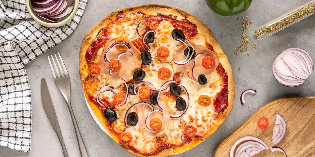 Pyszna pizza z szynką, oliwkami i pomidorkami. Proste ciasto na pizzę zawsze wychodzi, a składniki na blacie zachęcają do kolejnego kawałka.