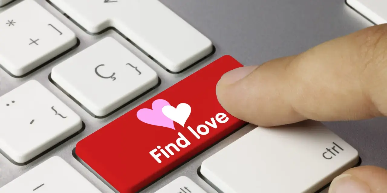 Palec naciska czerwony klawisz z sercami i napisem "Find love", symbolizując bezpieczne randki online.