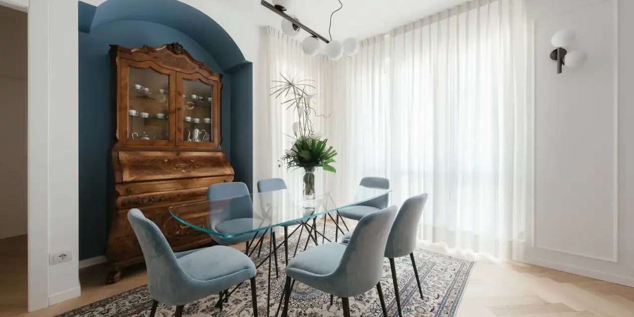 Un soggiorno classico con un mobile antico e un tavolo in vetro. I colori delle pareti del soggiorno classico sono un blu intenso e un bianco luminoso, creando un'atmosfera elegante.