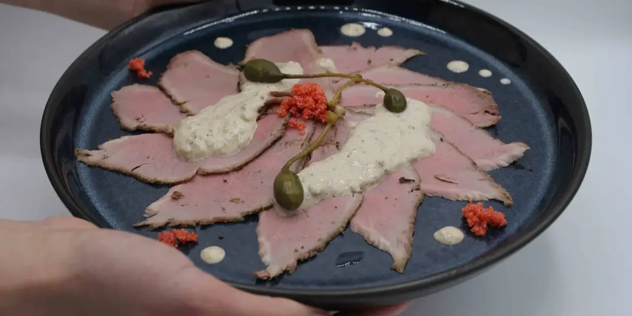 Vitello Tonnato: hauchdünne Scheiben Kalbfleisch, belegt mit cremiger Thunfischsauce, Kapern und roten Kaviar-Kügelchen.