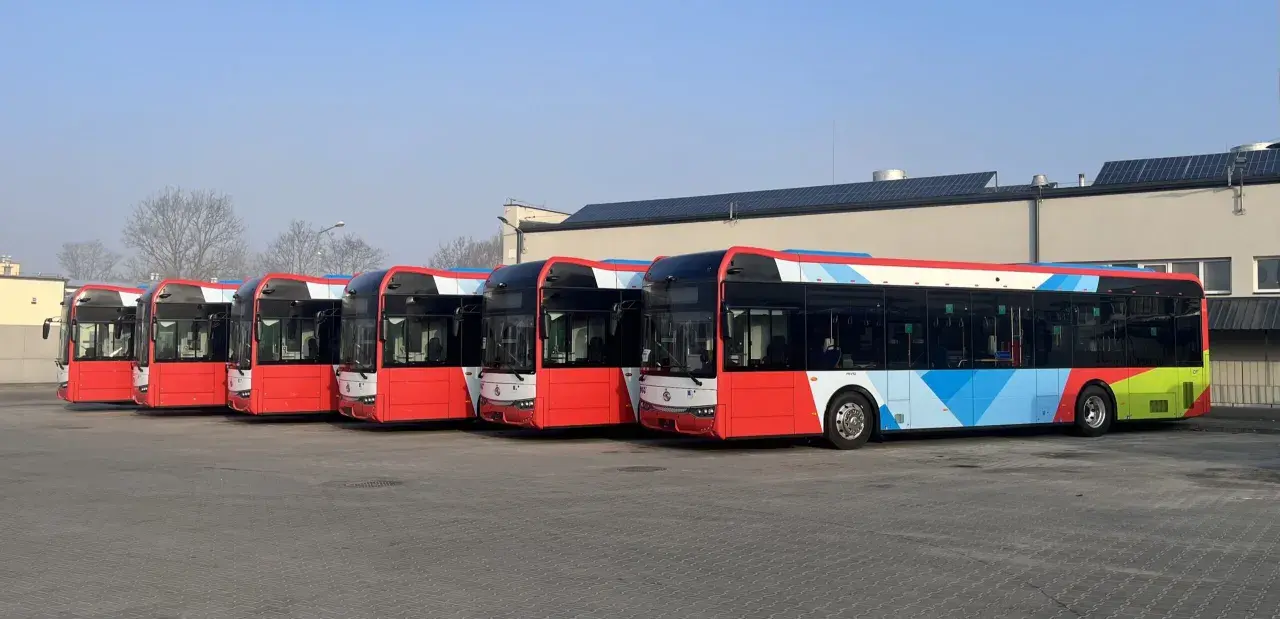 Rzędy czerwonych autobusów z kolorowymi wzorami czekają na swój z1 rozkład jazdy.