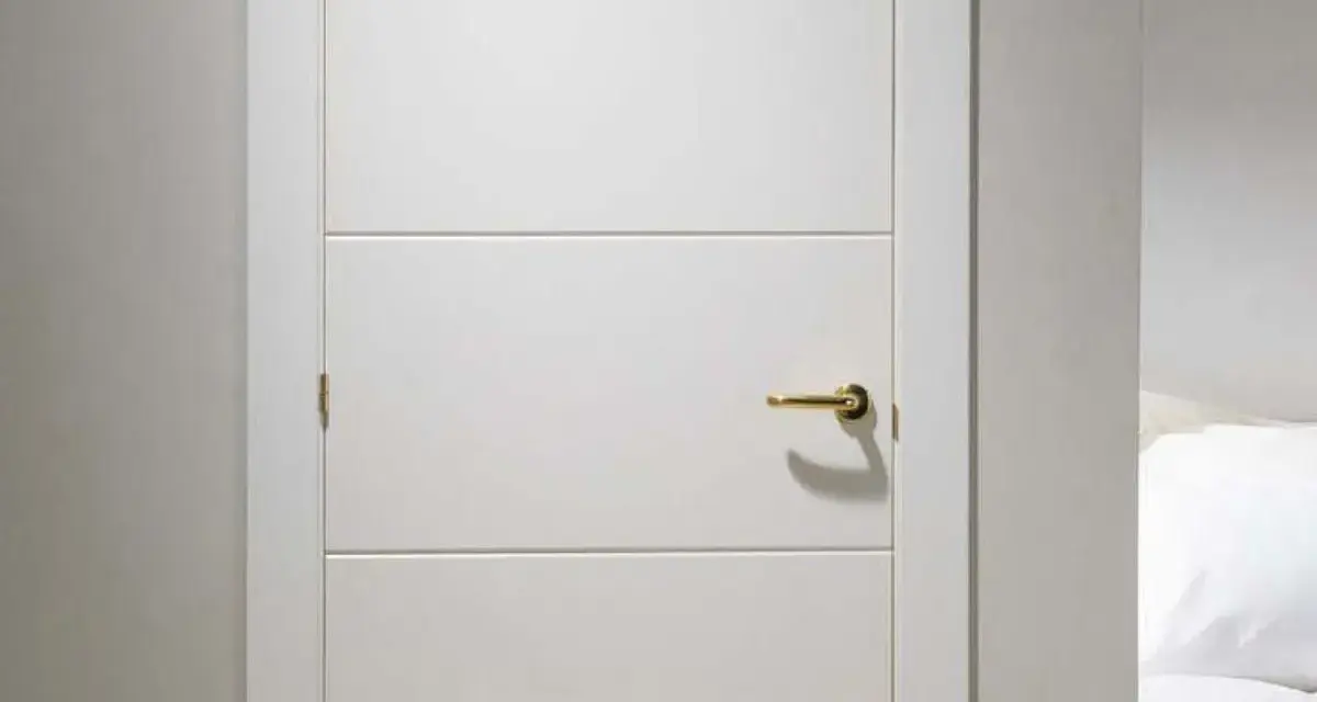 Puerta lacada en blanco con tirador dorado. Aprende como limpiar puertas lacadas en blanco para mantenerlas impecables.