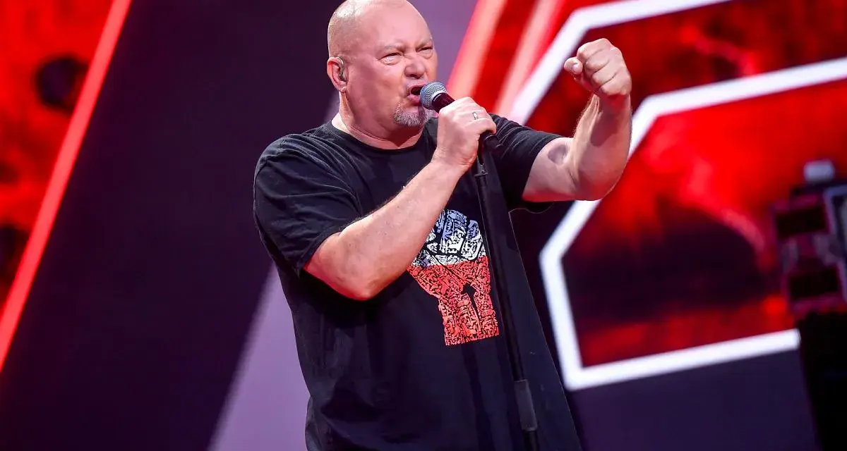 Tomasz Olejnik śpiewa z podniesioną pięścią, symbolizując siłę proletariatu.