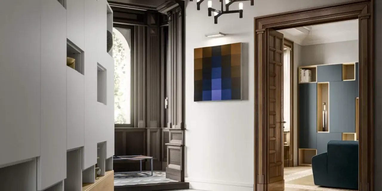 Ingresso di ville liberty moderne con arredi minimalisti, un quadro astratto e un lampadario scenografico.