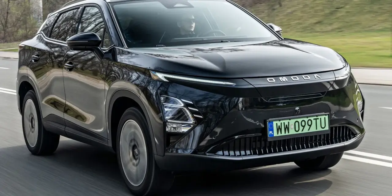 Czarny OMODA elektryk w ruchu drogowym. Nowoczesny design z charakterystycznym pasem świateł LED i logo marki.