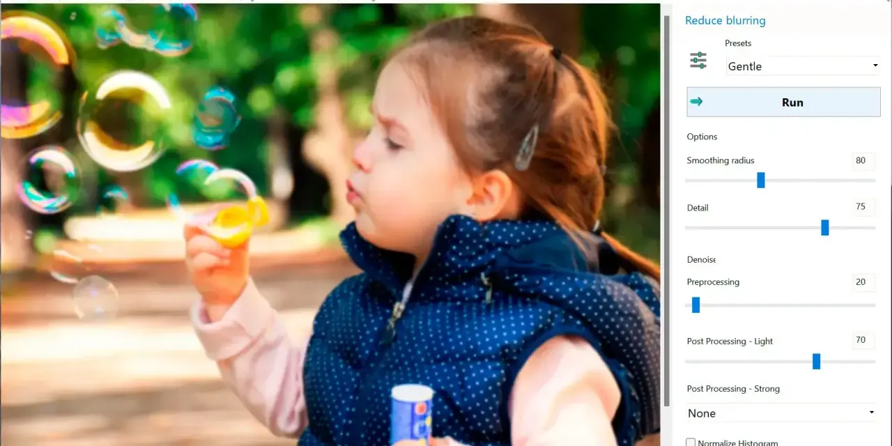 Dziewczynka dmucha bańki. Program Easy Photo Unblur pomaga jak wyostrzyć zdjęcie, oferując opcje redukcji rozmycia i poprawy detali.