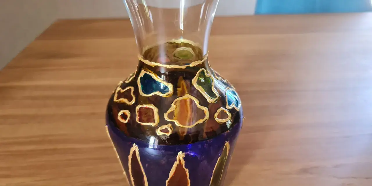 Vase en verre décoré de motifs abstraits colorés, une peinture acrylique sur verre qui évoque des vitraux.