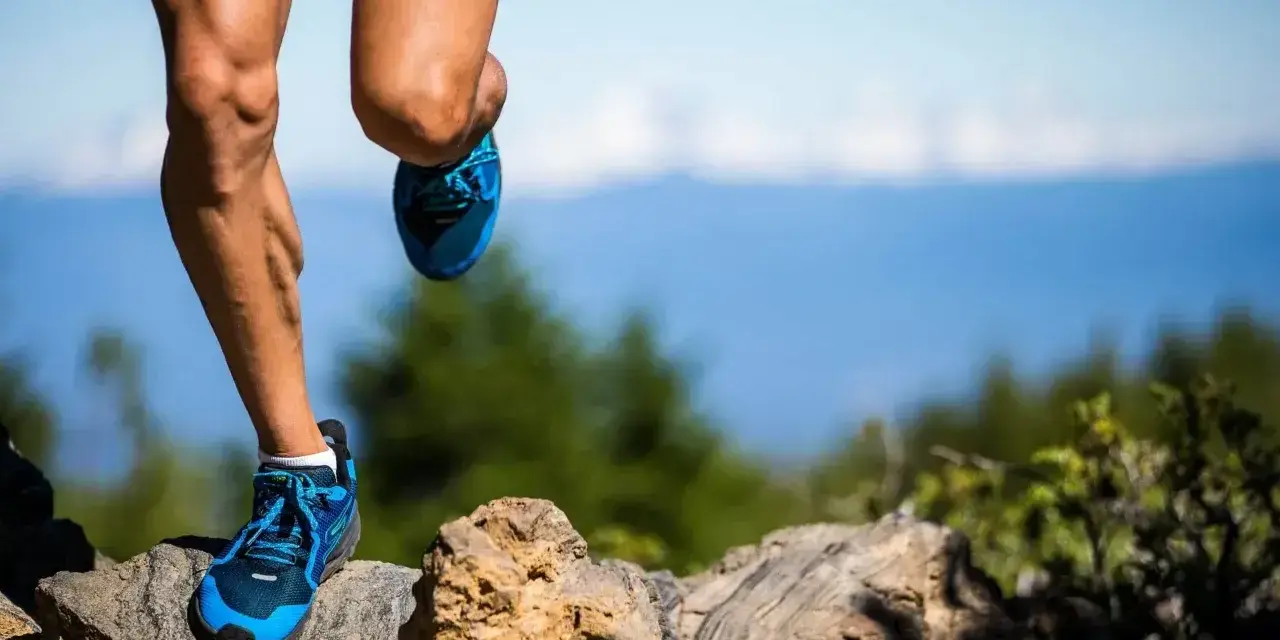 Nogi biegacza na kamienistym szlaku, przygotowującego się do ultramaratonu. Ile km jeszcze do mety?