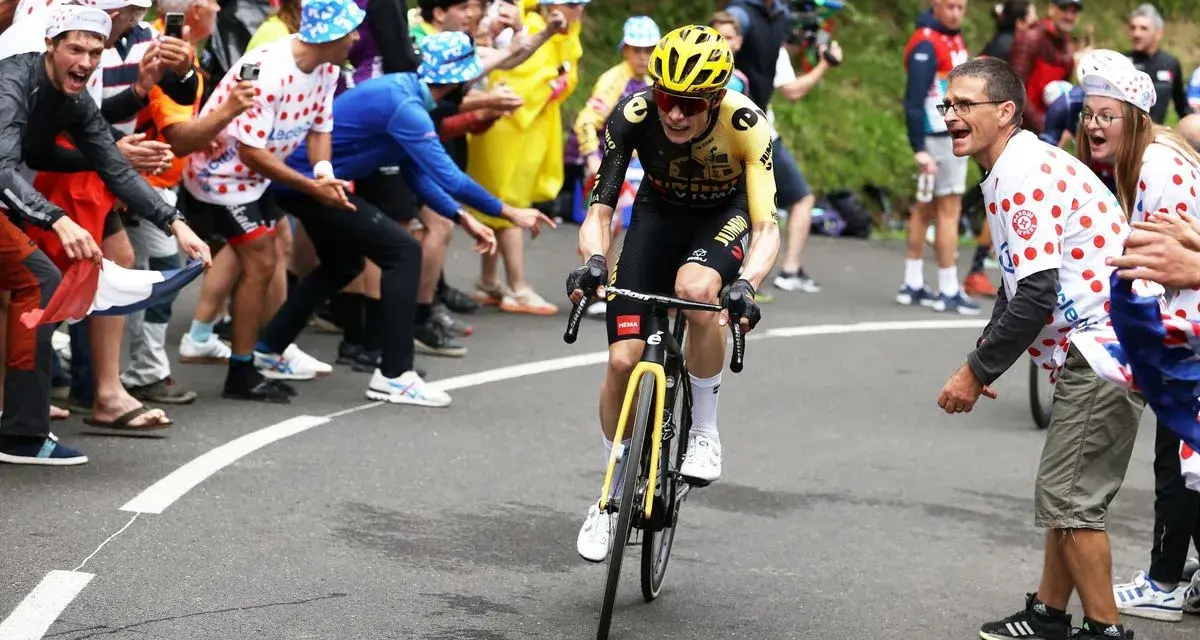 Jonas Vingegaard, with his impressive VO2 max, powers through a crowd of cheering fans in a cycling race.