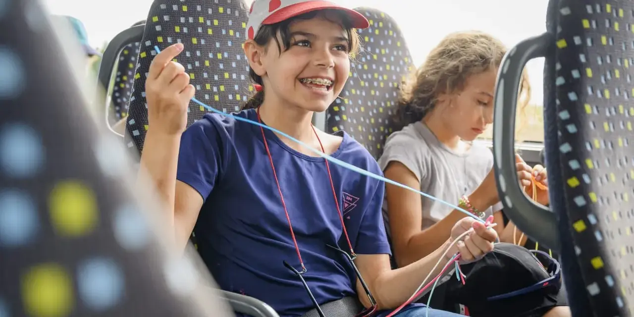 Deux enfants créatifs dans un bus, s'adonnant à une activité manuelle. Une belle illustration de l'éducation populaire en mouvement.