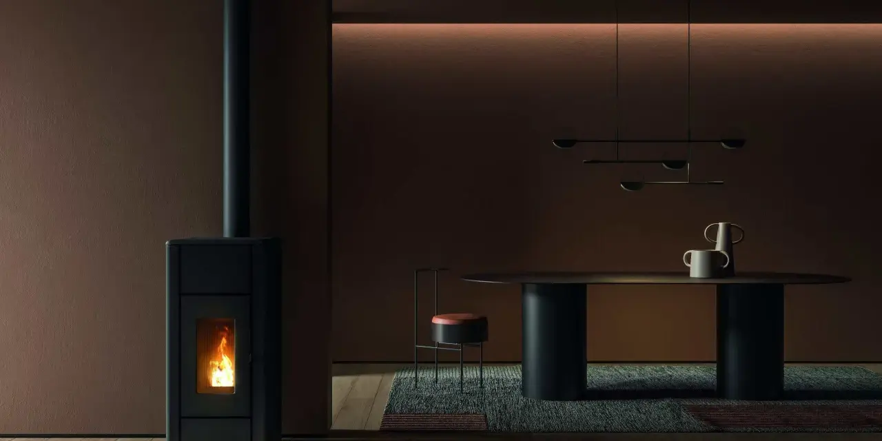 Un poêle à granulés dégage une douce chaleur, la flamme danse dans la chambre de combustion. La température ambiante est agréable, la fumée s'échappe par la cheminée.