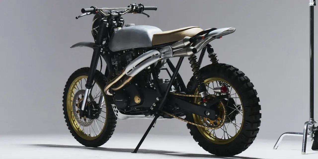 Stylowy motor scrambler z matowym, srebrnym bakiem, podwójnym wydechem i terenowymi oponami. Gotowy na przygodę!