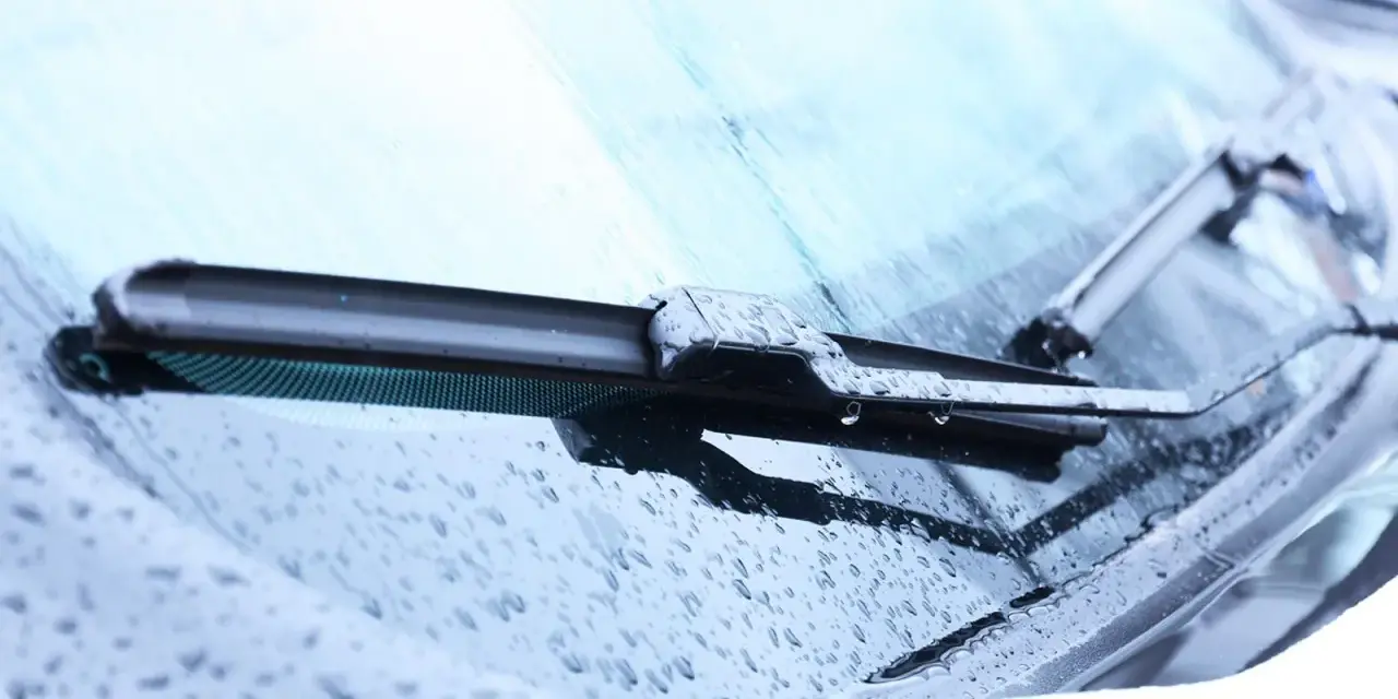 Scheibenwischer mit Wassertropfen. Die Scheibenwaschanlage funktioniert nicht. Woran kann das liegen? Vielleicht ist die Düse verstopft oder die Pumpe defekt.