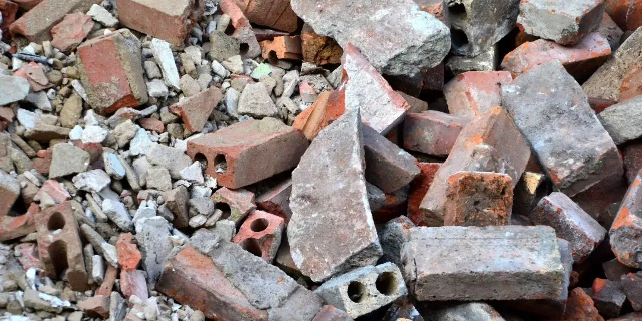 Stos gruzu budowlanego, cegieł i betonowych fragmentów. To materiał, który może być zaklasyfikowany jako gruz kod odpadu.