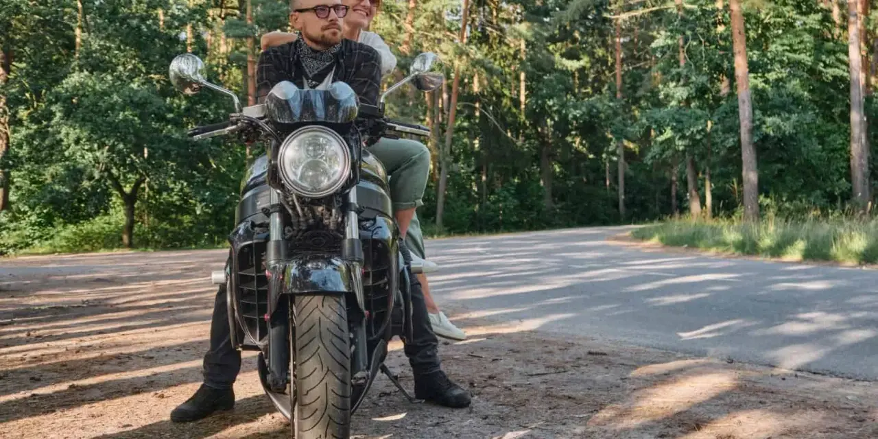 Para wyrusza na motocyklu przez las, marząc o podróży przez Karpaty i Sudety.